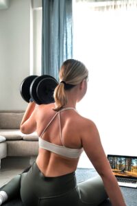 Woman lifting weights with strong form, showing the kind of training that helps when working out but not seeing results.