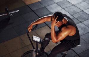 Person resting after a tough session, capturing the frustration of working out but not seeing results yet.