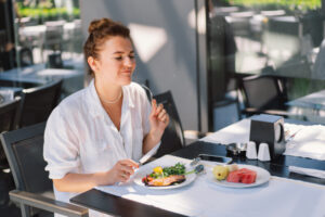 Woman eating a healthy lunch, showing a balanced approach to nutrition that fits real life.