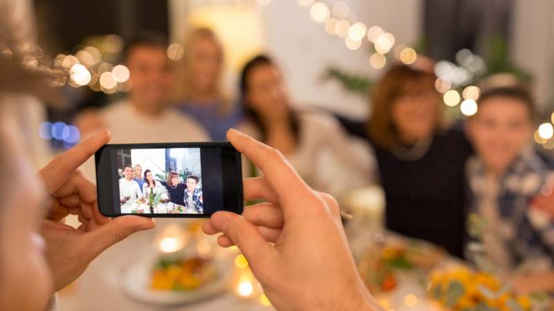 Parent taking a family photo but not appearing in the picture, representing avoiding photos and missing memories