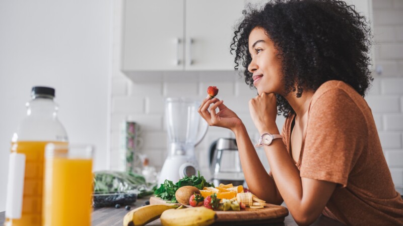 person preparing balanced meal with protein and vegetables to support fat loss